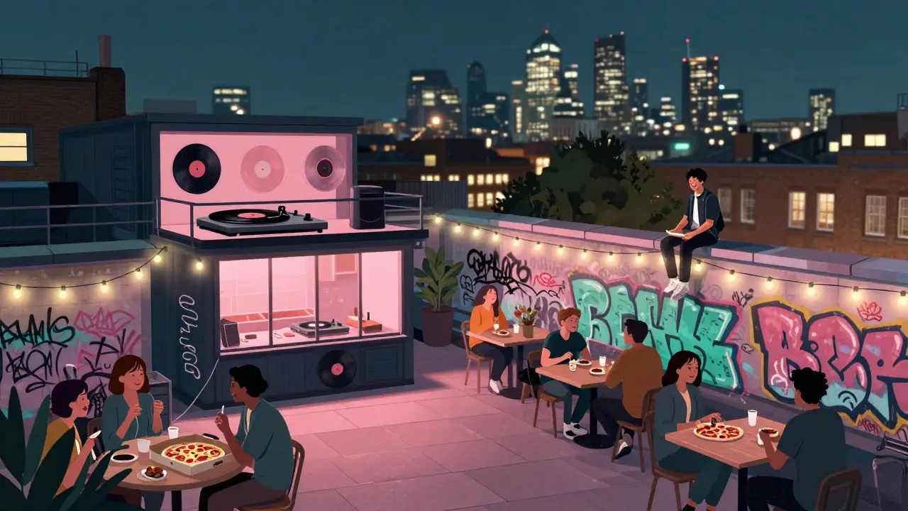 A lone person enjoys pizza on a rooftop terrace at Peckham Levels with vinyl records playing nearby.