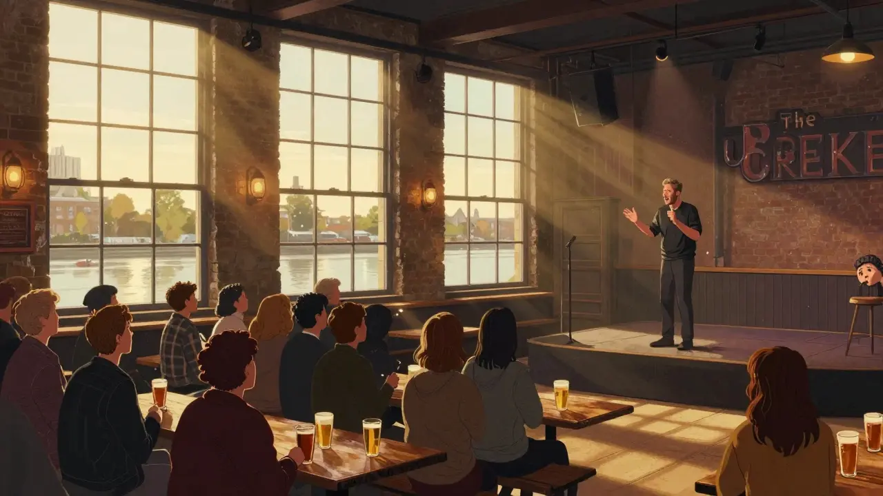 Intimate comedy show in a riverside warehouse with audience enjoying drinks and laughter.